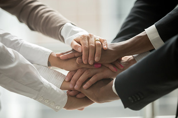 Diverse people putting stacked hands together promising help and support starting common business, black and white multiracial group unite at motivating training, team building concept, close up view